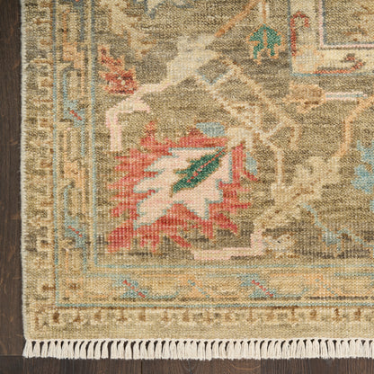 Woven wool oriental rug in beige tones with blue border, red leaf motif, geometric pattern, white fringe along bottom.
