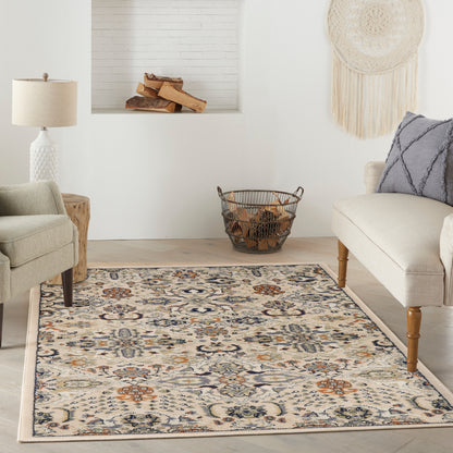 Neutral living room with beige seating, blue patterned area rug, log basket, fireplace alcove, & woven wall hanging.