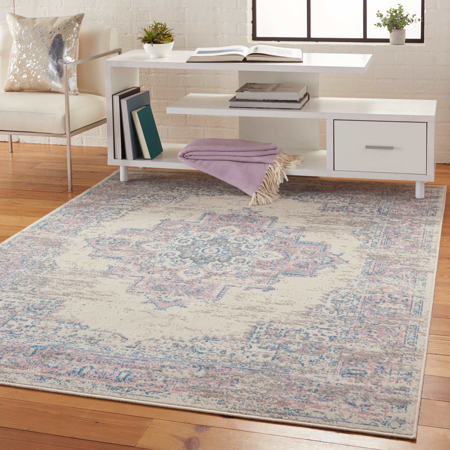 Vintage 4' x 6' oriental rug in faded blue and pink tones, shown in a living room.