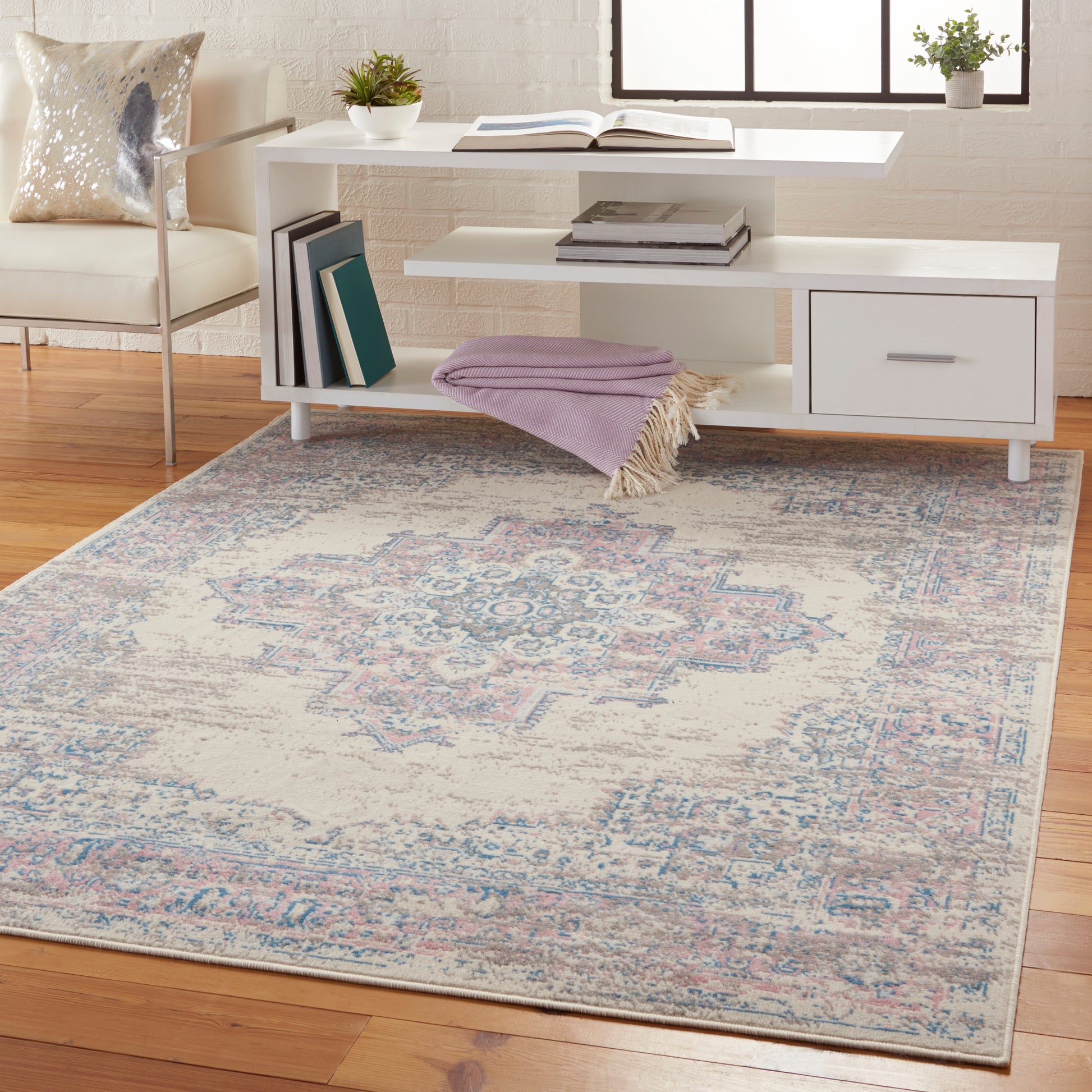 Vintage 4' x 6' oriental rug in faded blue and pink tones, shown in a living room.