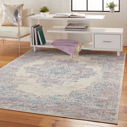 Vintage 4' x 6' oriental rug in faded blue and pink tones, shown in a living room.