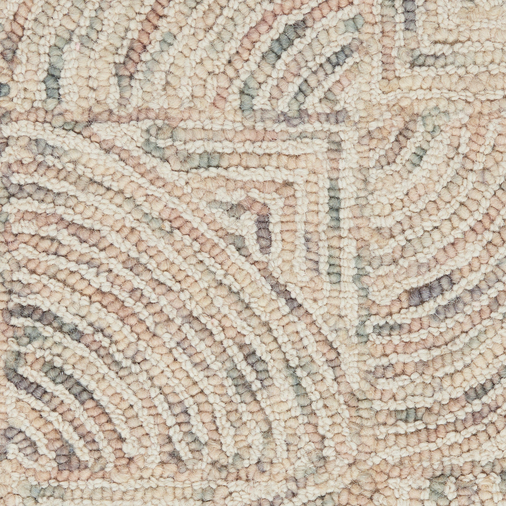 Boucle woven rug close-up with circular spiral motifs in cream, blush pink, light gray and sage.