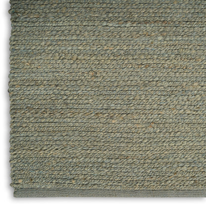 Close-up of an olive-gray loop-pile rug with dense woven loops and a bound edge.