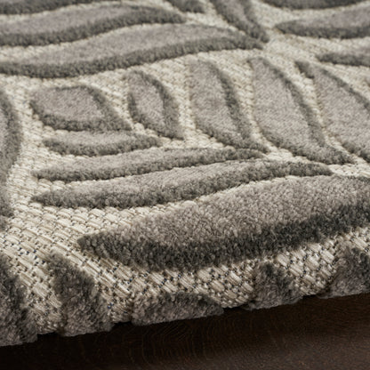Close-up of a beige and gray patterned rug with plush loop-pile and geometric motifs.