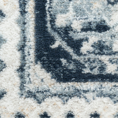 Plush navy and ivory patterned area rug close-up with a soft shag pile and geometric border