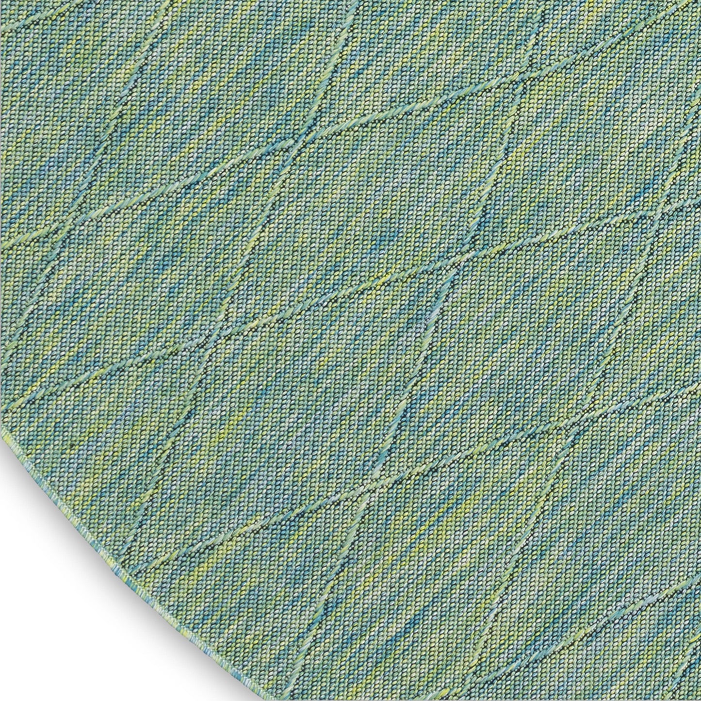 Round denim-style rug in blue-green with diagonal diamond-quilt stitching and yellow speckles