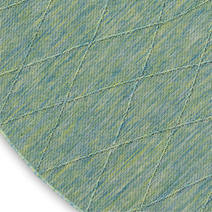 Round denim-style rug in blue-green with diagonal diamond-quilt stitching and yellow speckles