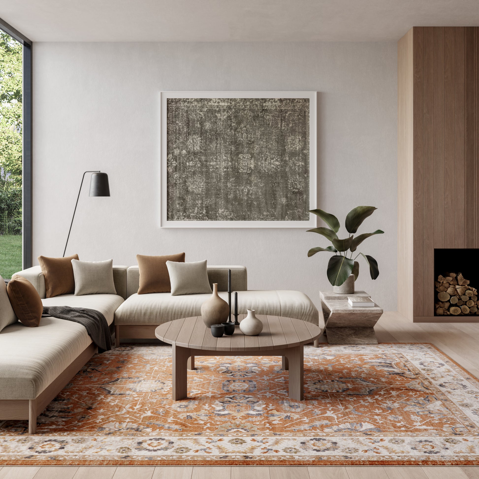 Modern beige sectional living room with a round wood coffee table, abstract art, orange patterned rug, plant, and floor lamp.