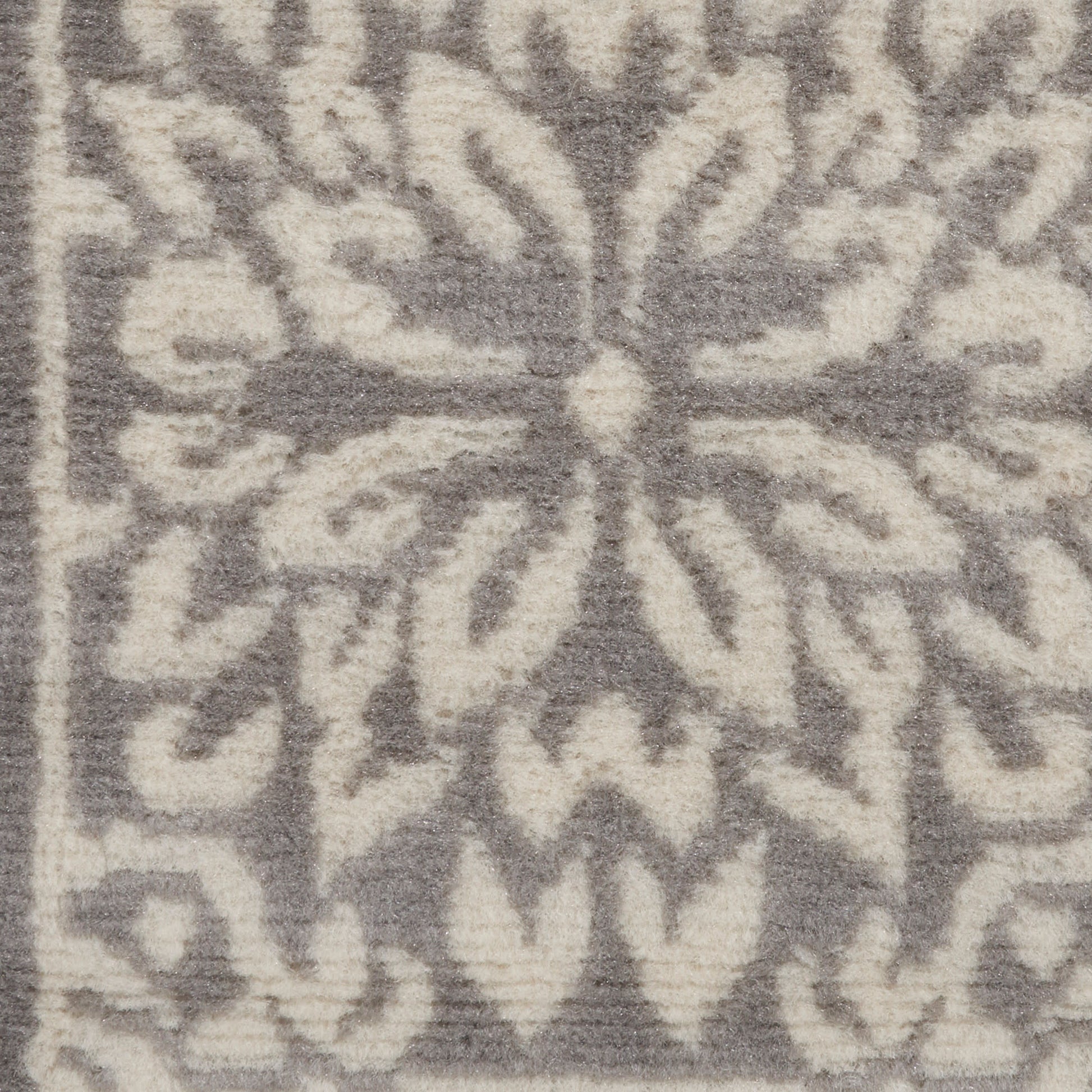 Gray rug with cream snowflake/medallion damask pattern, soft textured surface; decorative floor accent.