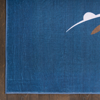 Blue rug with white curved arc and brown accent, edge stitching visible on wooden floor.