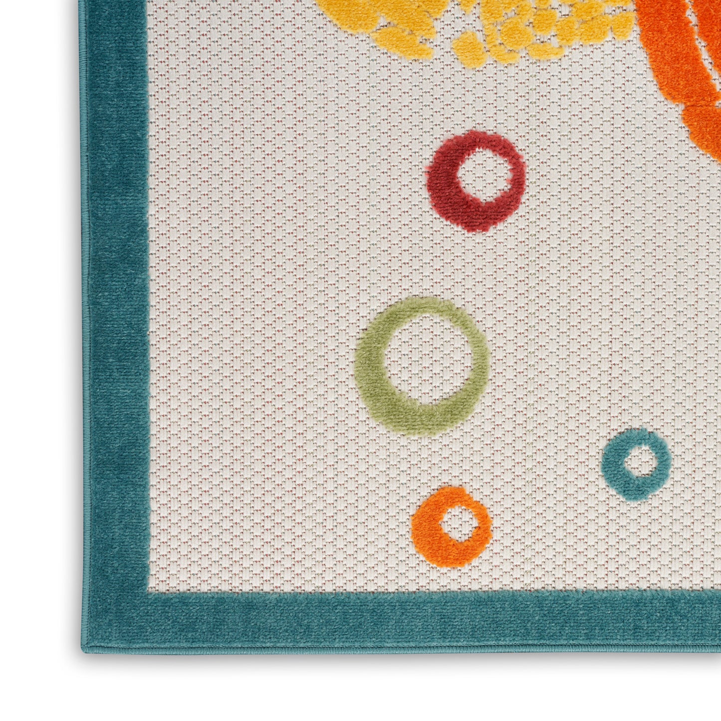 Close-up of a cream woven rug with teal border & scattered colorful circular rings in red, green, orange & teal.