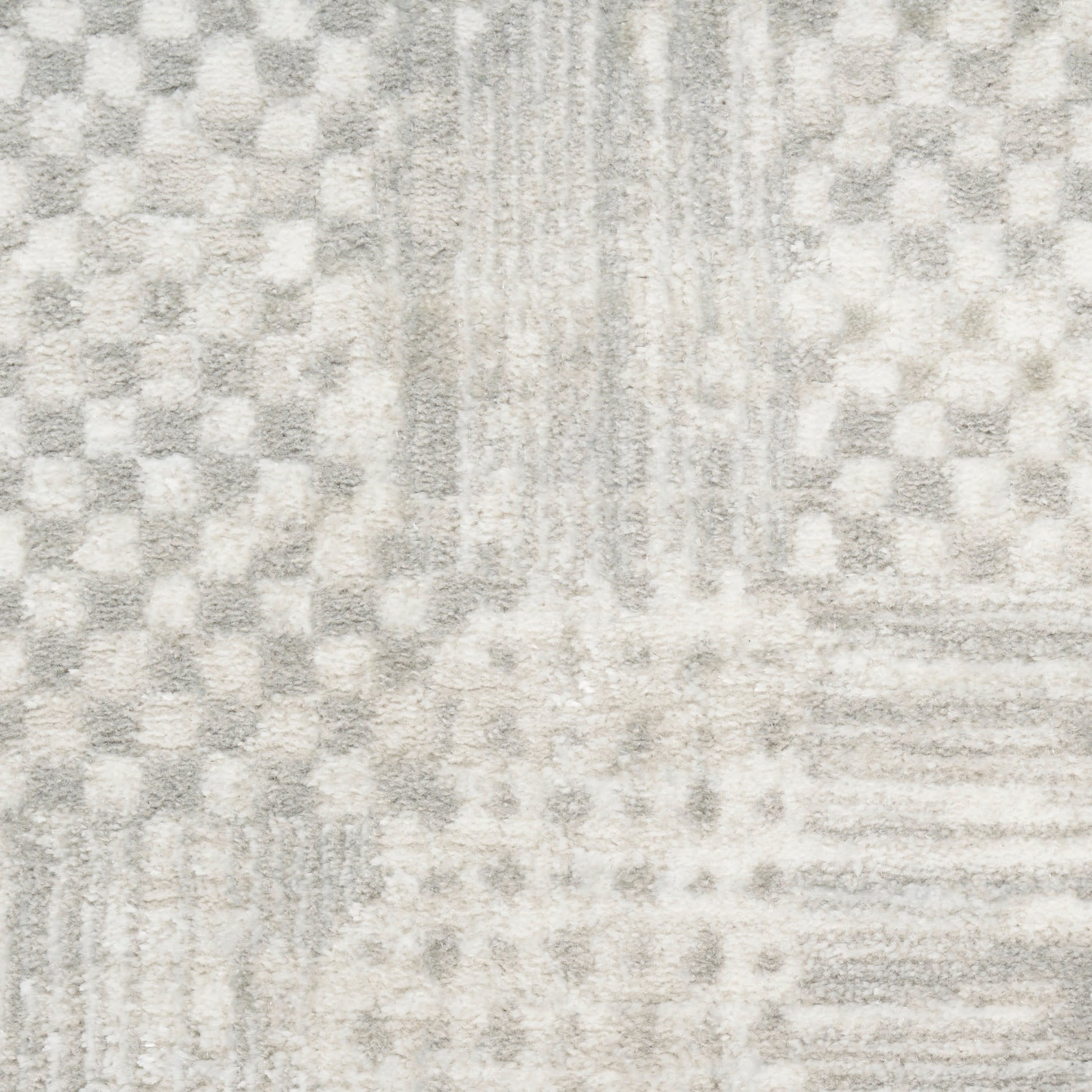 Light gray plush area rug with geometric patchwork of squares and subtle stripes for modern, neutral decor.