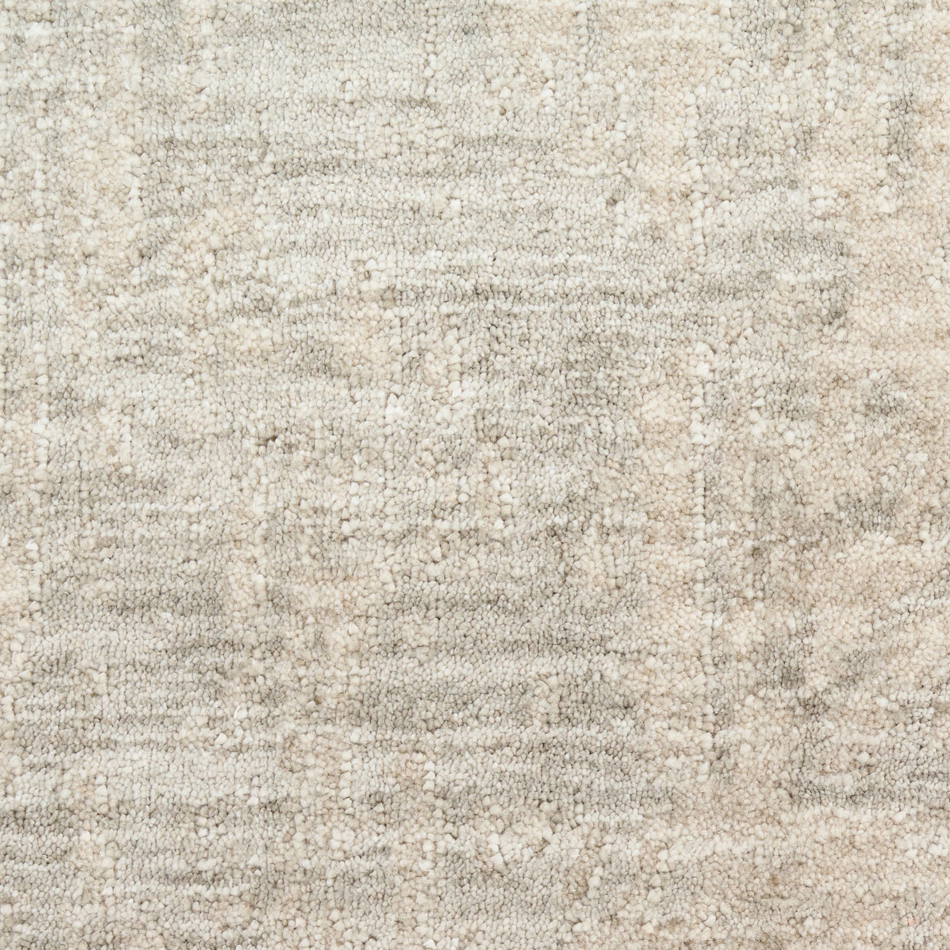 Cream-beige woven area rug with subtle mottled texture and soft, plush feel.