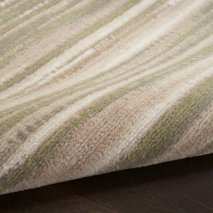 Soft striped round area rug with beige, tan and sage green tones, subtle wavy bands, plush pile on dark wood floor.