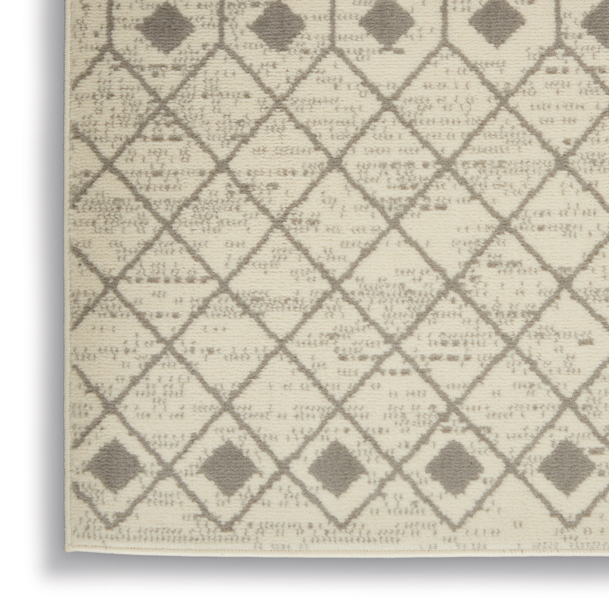 Beige rug with taupe diamond lattice pattern and small square accents at corners, textured woven surface.