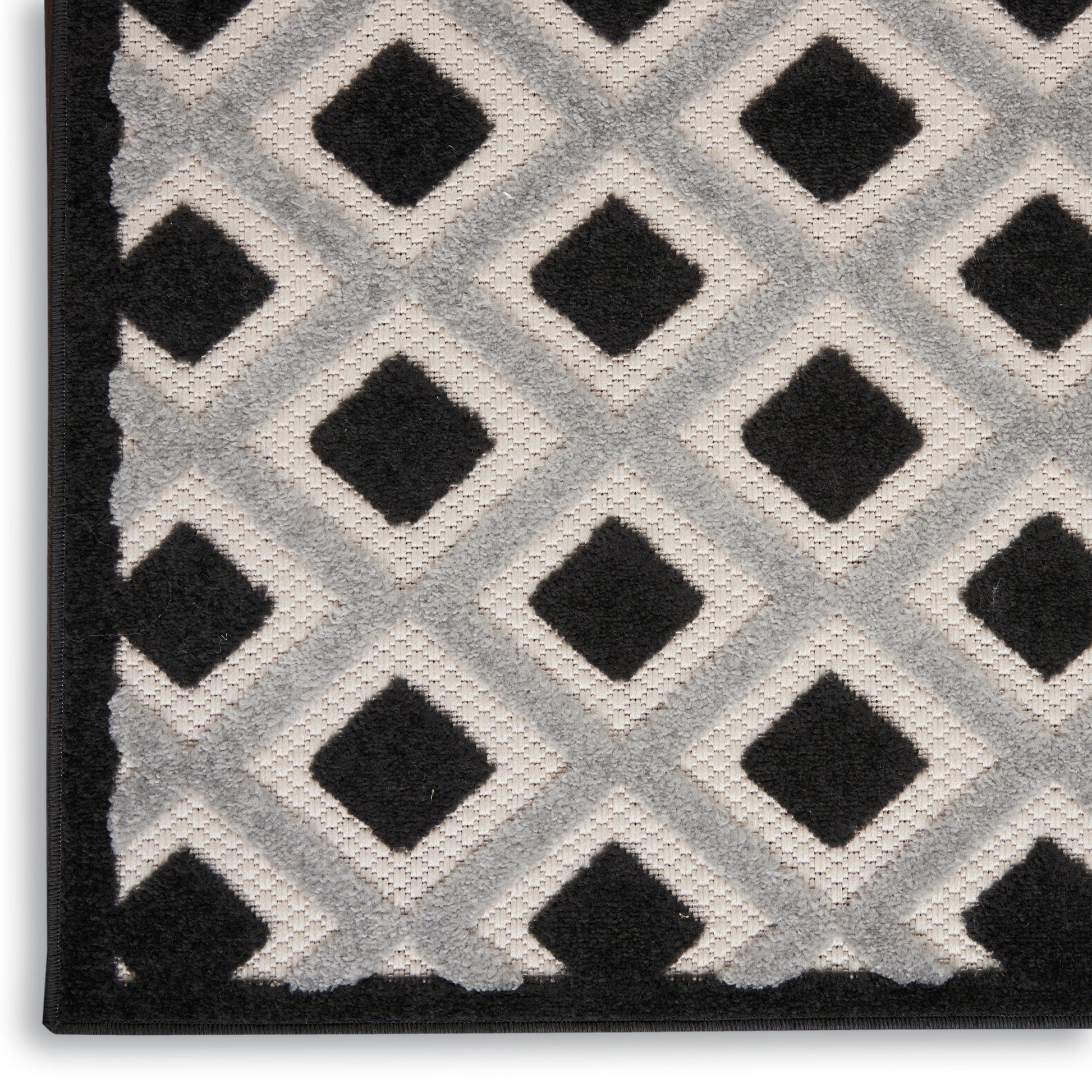 Geometric runner rug featuring black diamond shapes on a light gray field with a dark border.