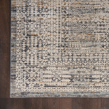 Distressed oriental runner rug in cream, gray, blue and tan tones with an ornate border on dark wood floor.