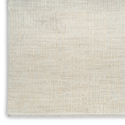 Cream textured rug with subtle grid pattern and white fringe along the edge.
