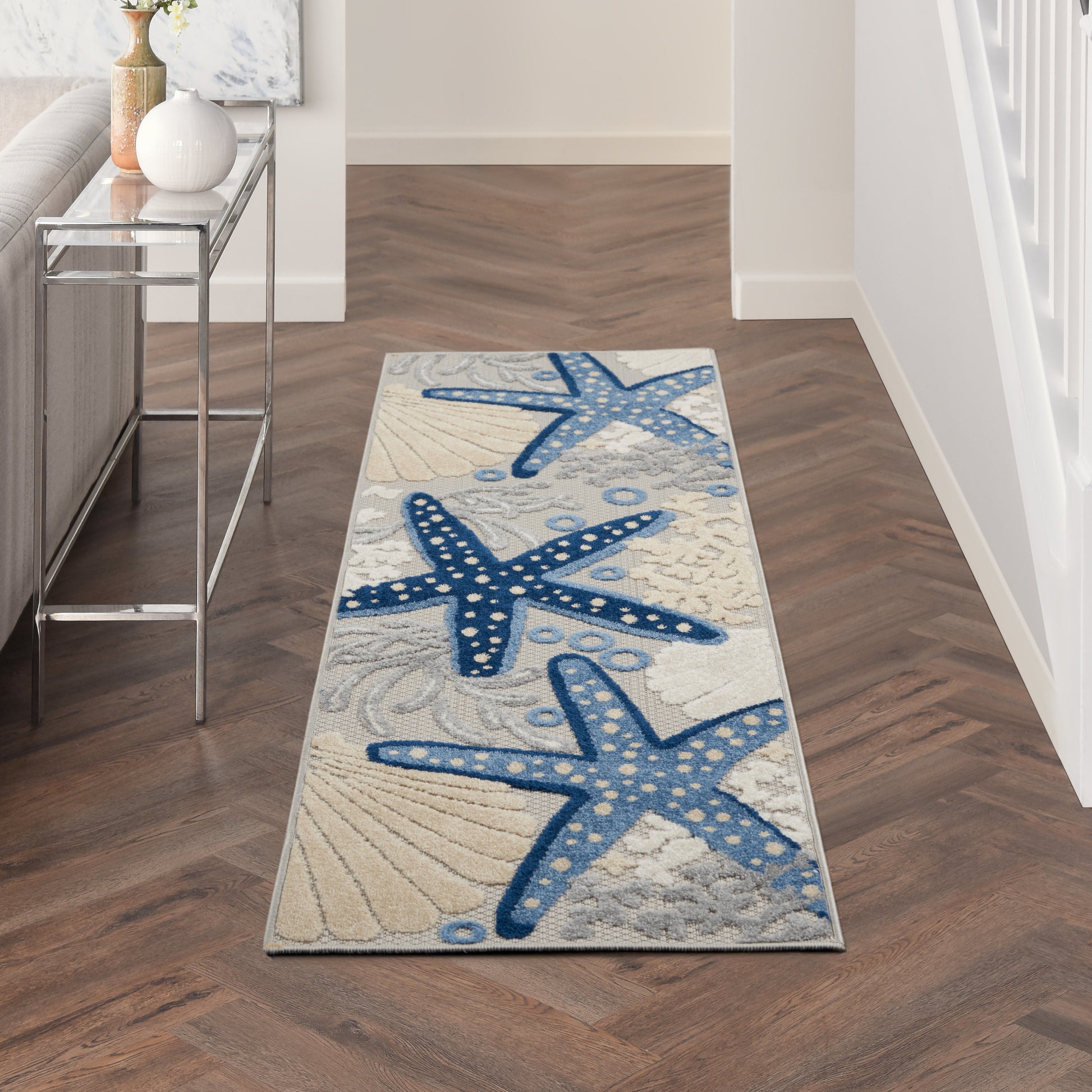 Coastal hallway runner rug with blue starfish pattern on sandy beige background; rectangular, soft fabric, beach decor.