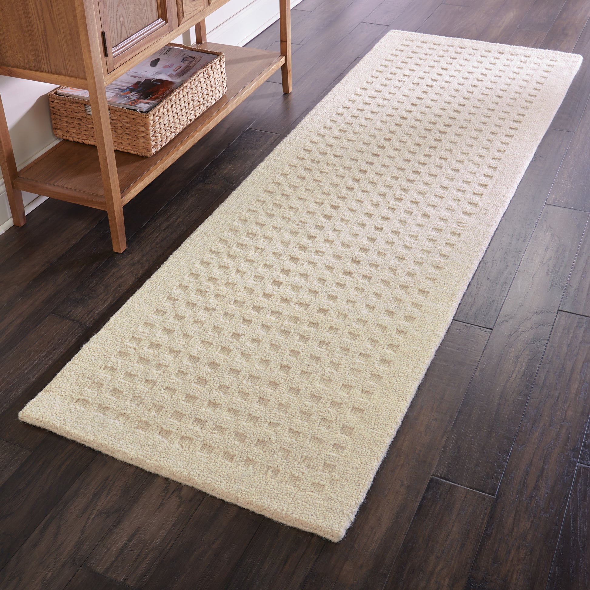 Cream textured hallway runner rug with embossed square grid pattern on dark wood floor.