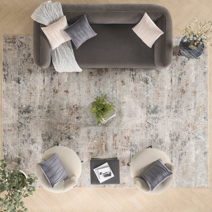 Top-down living room: gray sofa with beige cushions and knit throw, round beige poufs, rug, glass coffee table with plant.