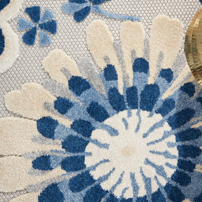 Blue and ivory floral rug with large round petal motif and woven texture.