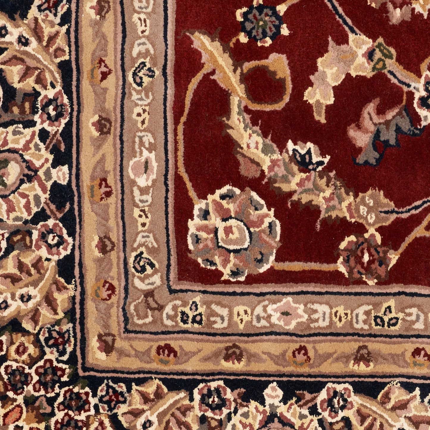 Close-up of a traditional oriental rug: burgundy field, cream floral motifs, and beige bordered edges.