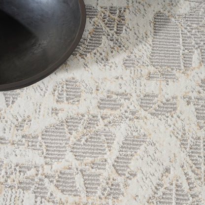 Dark round bowl atop a beige-gray geometric patterned rug.