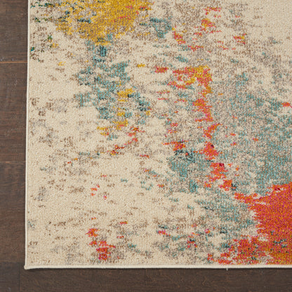 Modern abstract beige rug with teal, yellow, red blotches and a white fringe on dark hardwood floor.