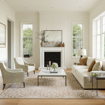 Bright contemporary living room with white walls, beige sofa, two armchairs, glass coffee table, fireplace, floral rug.