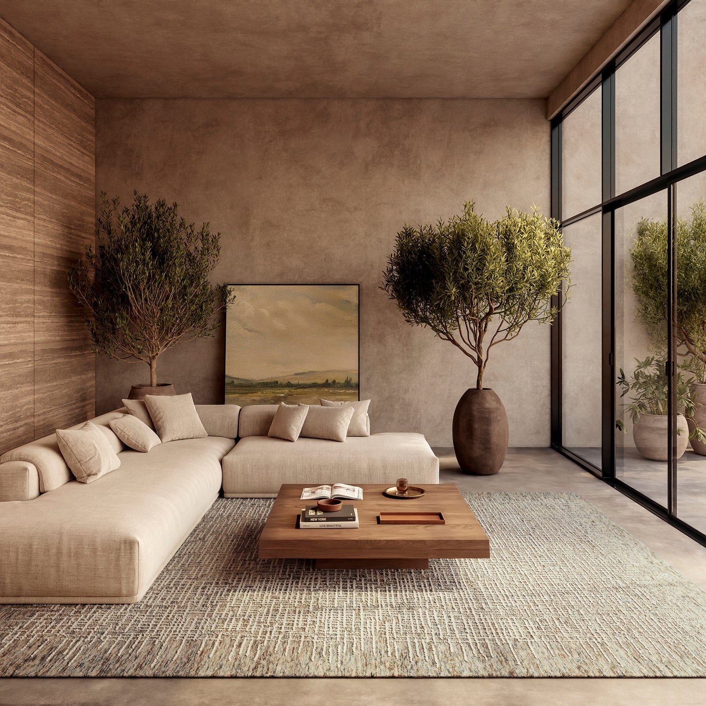 Neutral beige sectional sofa, wooden coffee table, large potted olive trees, textured rug, & floor-to-ceiling glass windows.