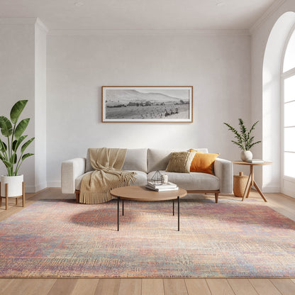 Cozy modern living room with beige sofa, cream throw, orange cushion, round wood coffee table, pastel rug, green plants.
