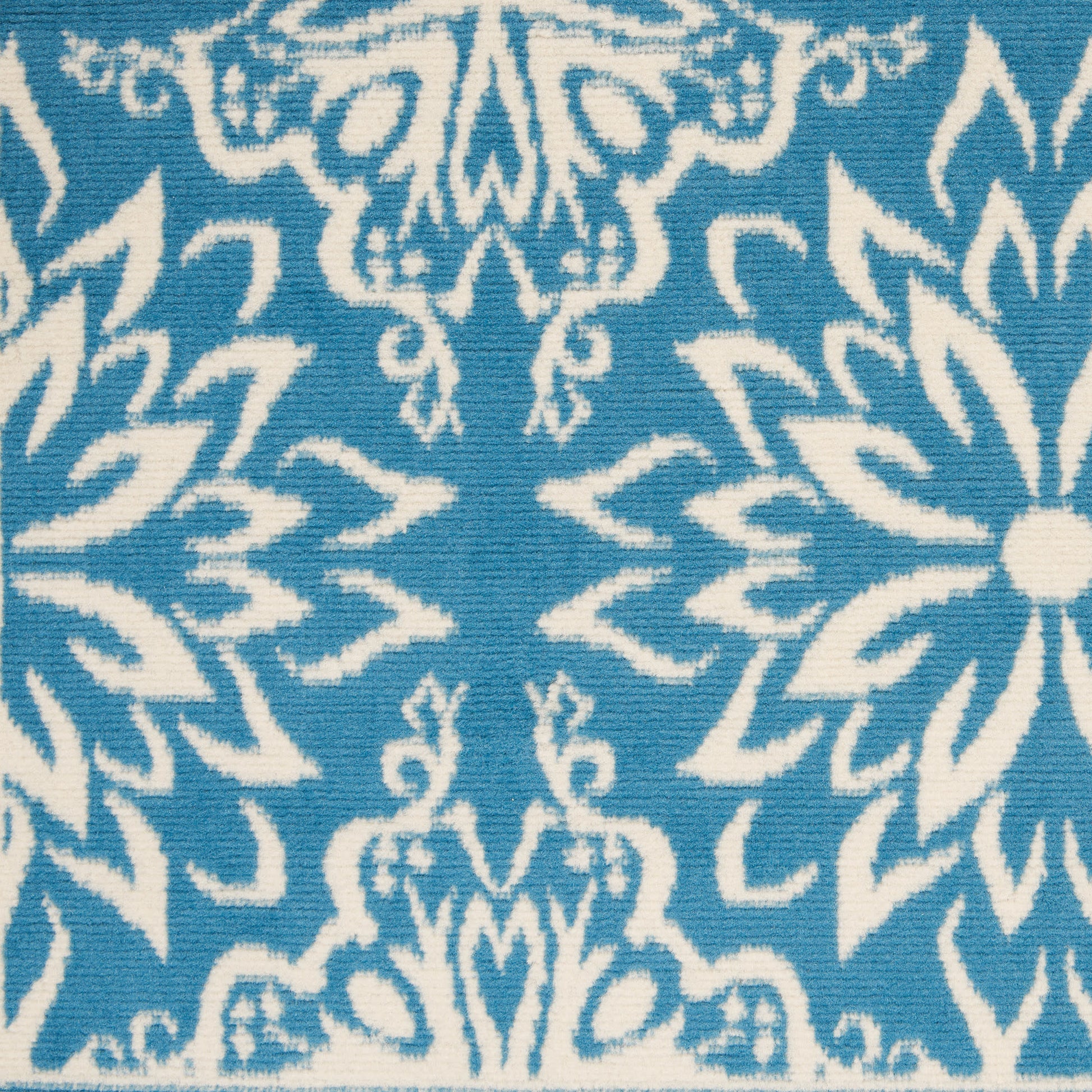 Teal blue fabric with white damask floral pattern; ornate textile for upholstery or home décor.