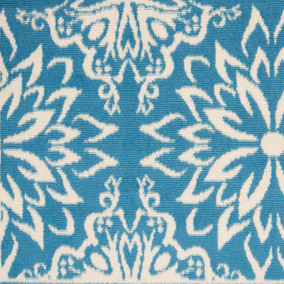 Teal blue fabric with white damask floral pattern; ornate textile for upholstery or home décor.
