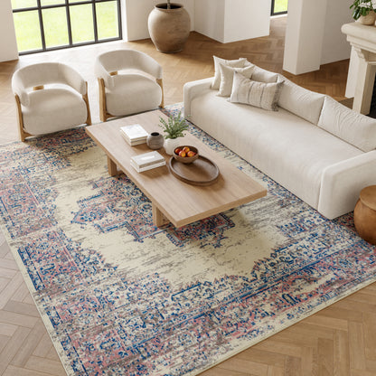 Cream sofa with curved-armchairs, wooden coffee table, and a patterned rug in a bright living room.