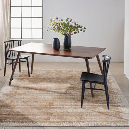 Mid-century walnut rectangular dining table with angled legs, black chairs, and a two-vase greenery centerpiece on a beige rug.