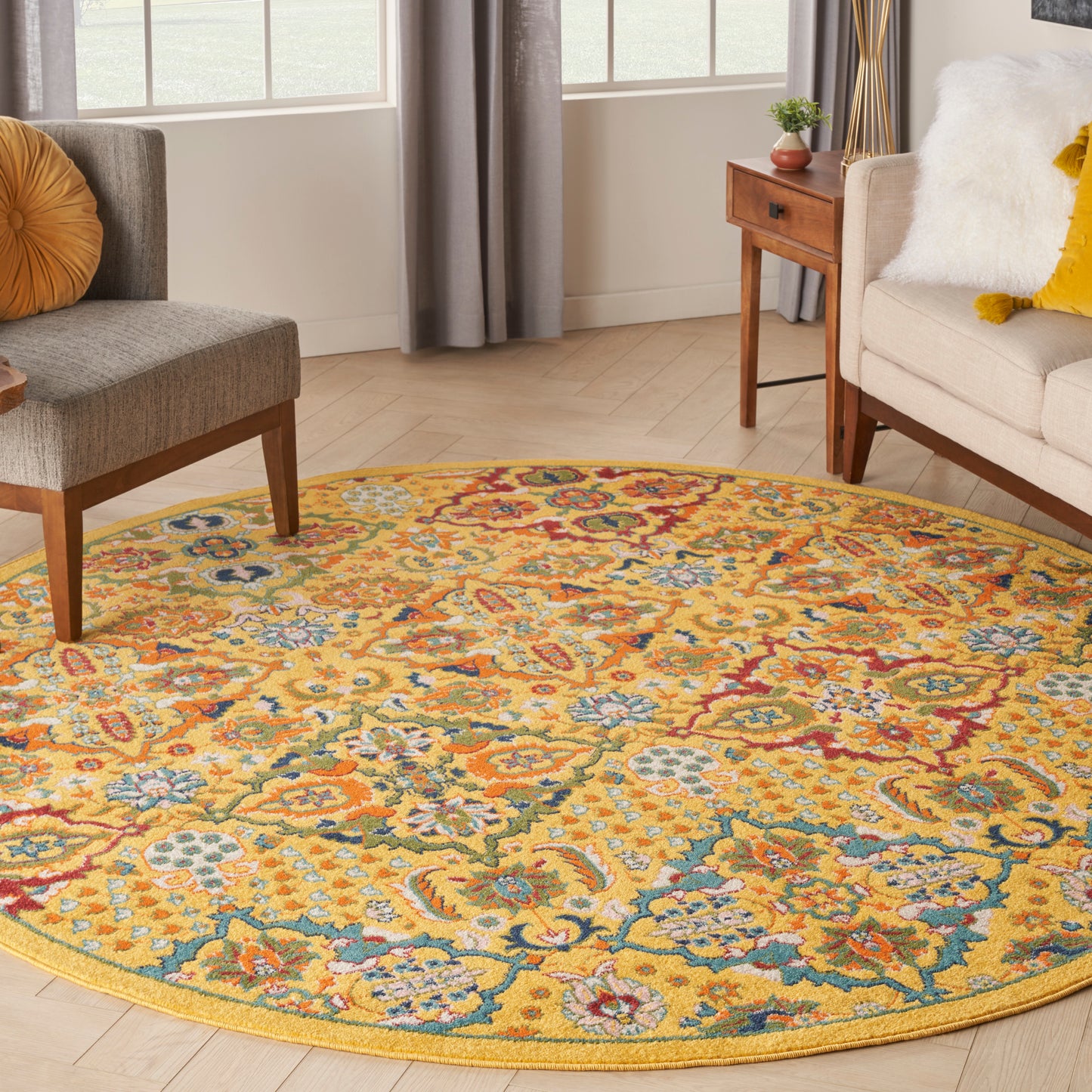 Round oriental-style floral rug with yellow background and blue, red, teal accents in a bright living room.