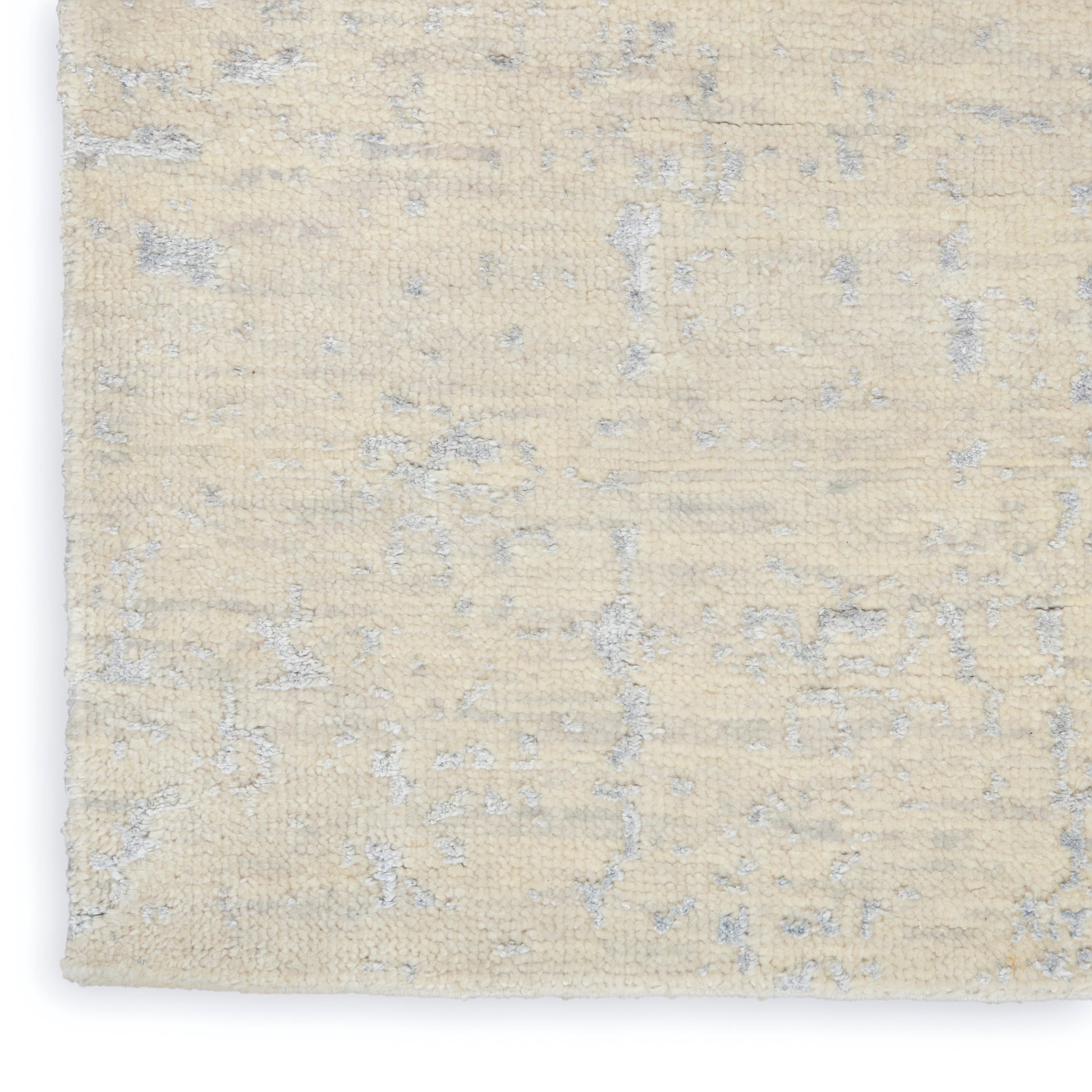 Beige area rug with subtle gray-blue abstract pattern; short pile, textured surface.