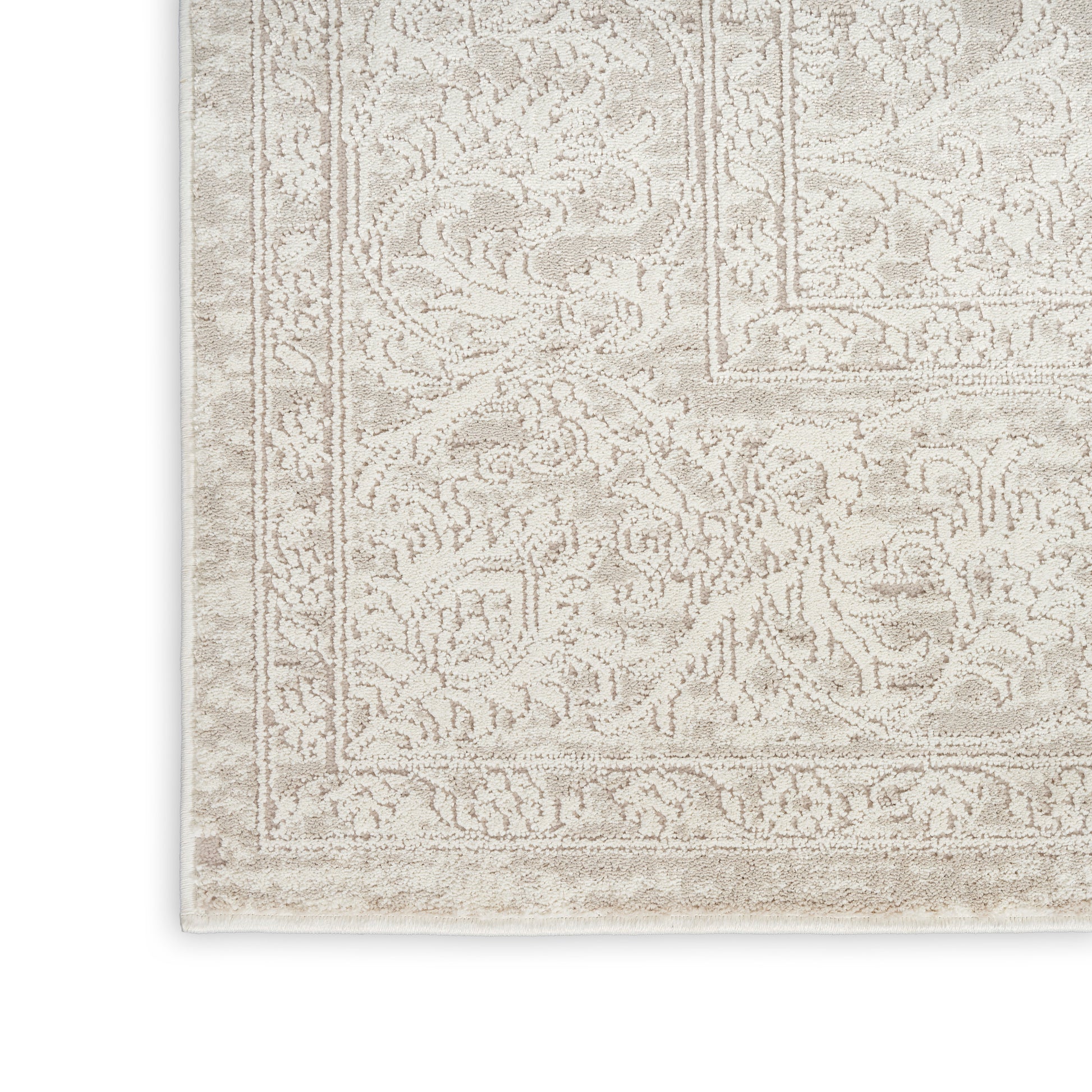 Beige ornate-pattern rug with floral border and vintage distressed texture.