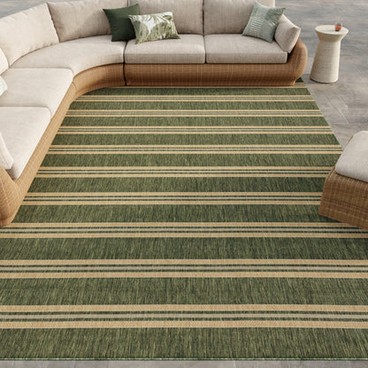 Green striped outdoor rug under a curved beige sectional with a wicker base in an outdoor living room with assorted throw pillows.
