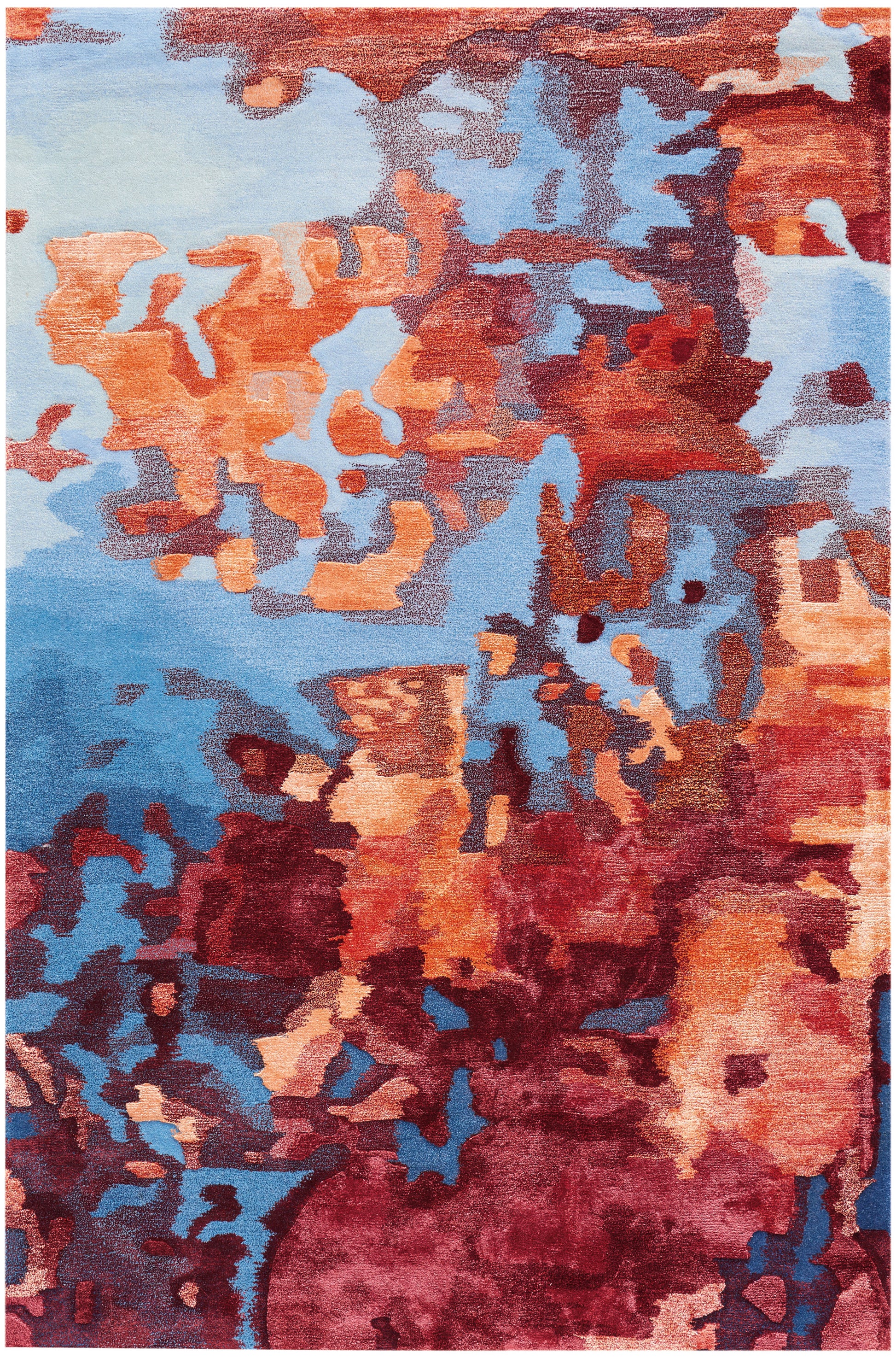 Abstract area rug featuring orange, rust and burgundy patches against blue tones in a modern irregular block pattern.
