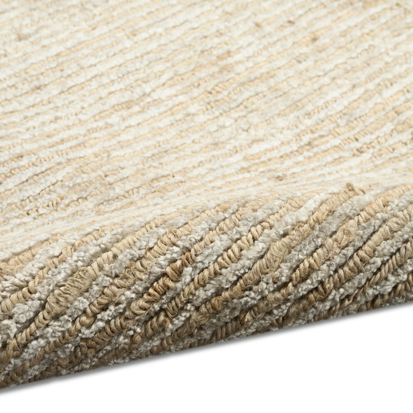 Beige cream textured rug with dense looped pile and rolled edge.