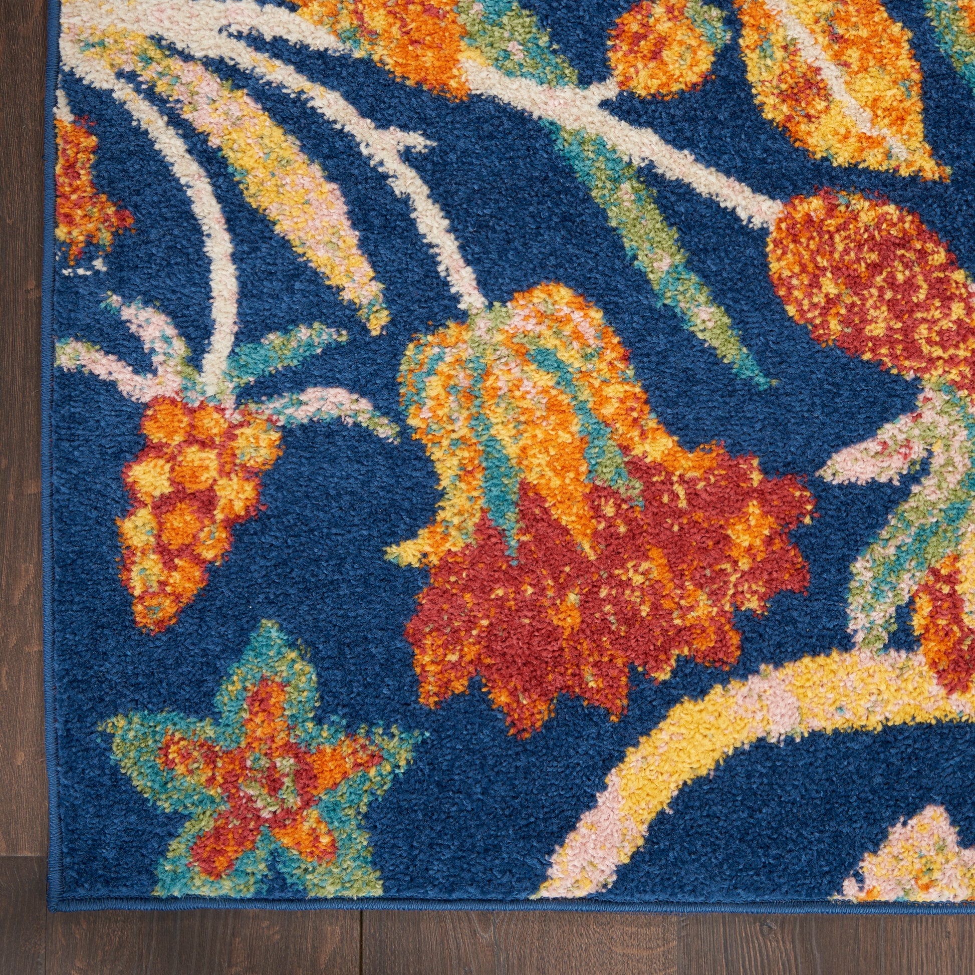 Blue floral runner rug with orange and yellow flowers, green leaves, cream vines, and textured pile.