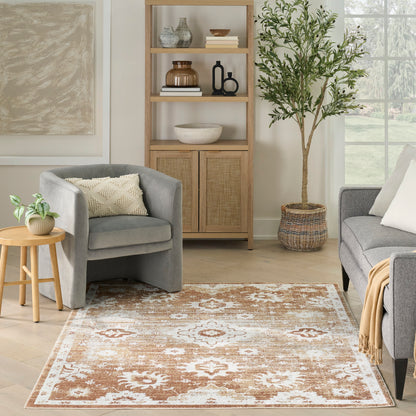 Cozy living room with a brown-and-white ornate rug, gray armchairs, light wood shelving, and a tall potted plant.