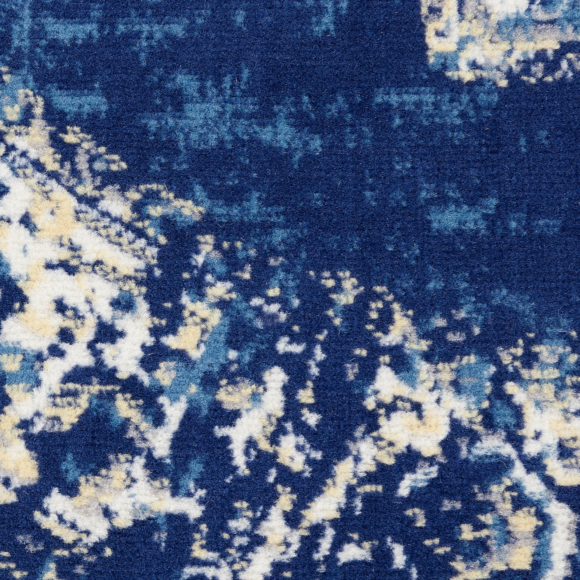 Close-up of a deep blue rug with abstract cream and pale blue speckles.