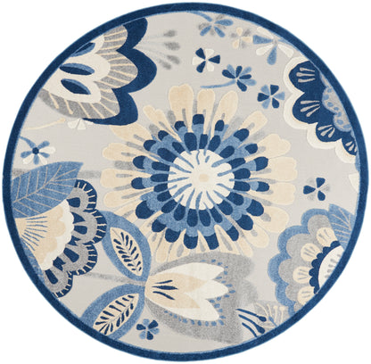 Round area rug with navy, blue and cream floral pattern, featuring a large central bloom and leafy motifs.