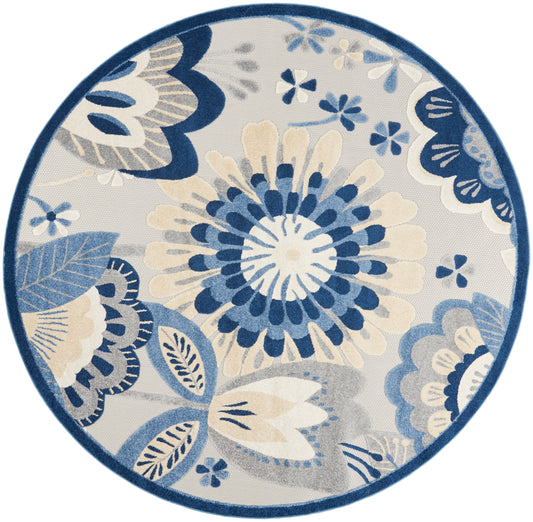 Round area rug with navy, blue and cream floral pattern, featuring a large central bloom and leafy motifs.