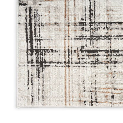 Abstract geometric beige rug with bold black and rust streaks, textured pile.