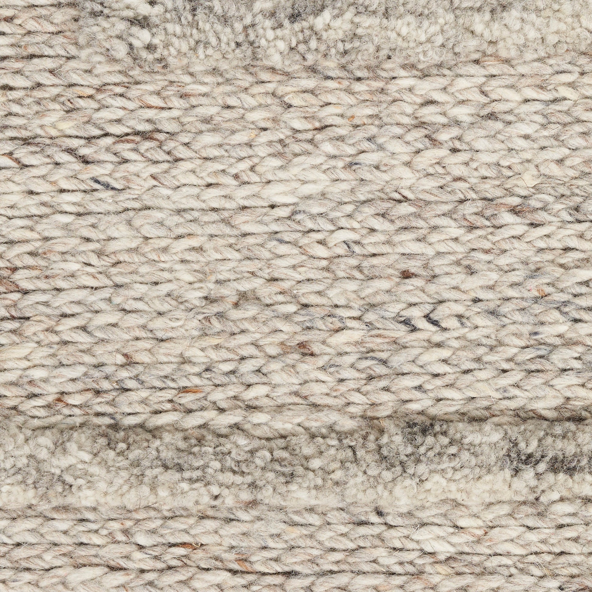 Beige chunky-knit wool rug close-up with looped fibers and a soft border for cozy living spaces.