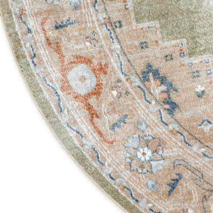 Partial view of a round oriental rug with peach background, blue and ivory floral motifs, and sage-green border.